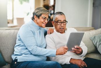 A couple on the couch holding an ipad