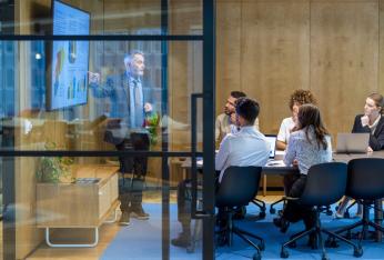 People in an office looking at a screen