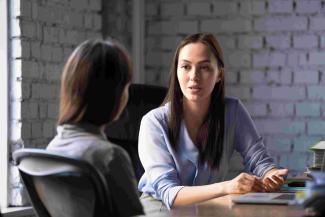 Two people talking at a desk