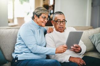 A couple on the couch holding an ipad