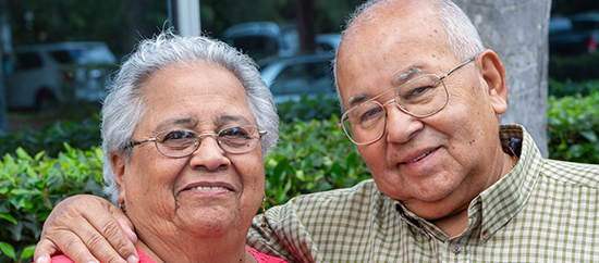 Smiling hispanic senior couple posing looking at the camera
